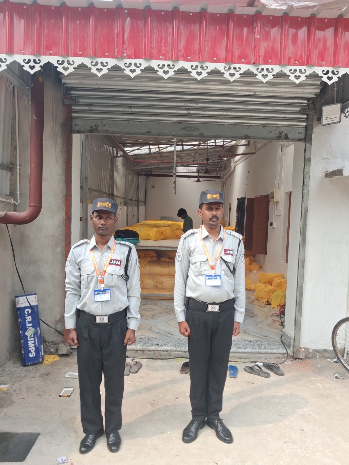 Two guards in white uniform at a factory gate